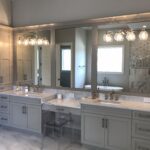 A bathroom with two sinks and mirrors and great lights
