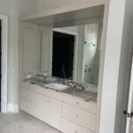 A bathroom mirror and cabinets