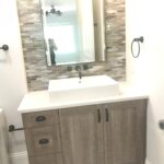 A small bathroom sink and cabinet