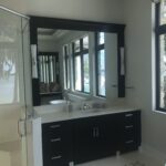 A huge mirror and bathroom sink