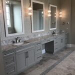 A bathroom with three mirrors and two sinks