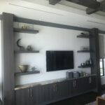 A mounted television near a black cabinet