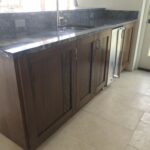 A kitchen island with a sink and wine cooler